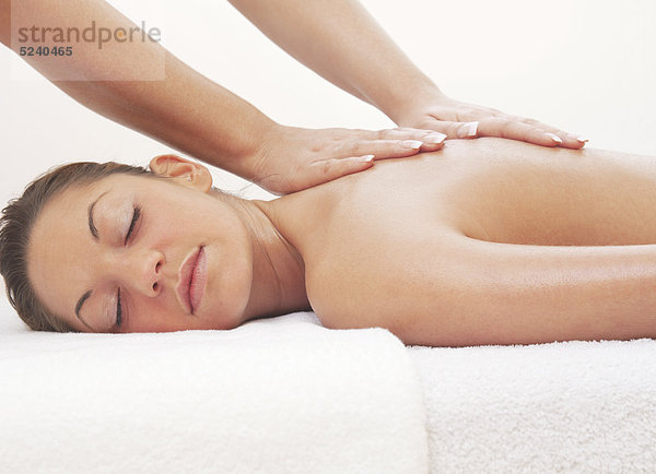 Frau liegt entspannt bei Massage-Behandlung