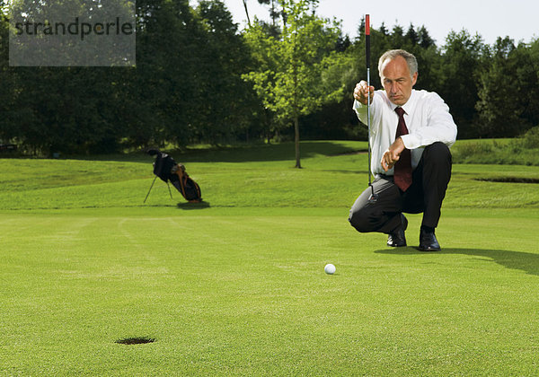 Älterer Manager auf Golfplatz