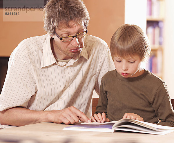 Vater mit Sohn beim Lesen
