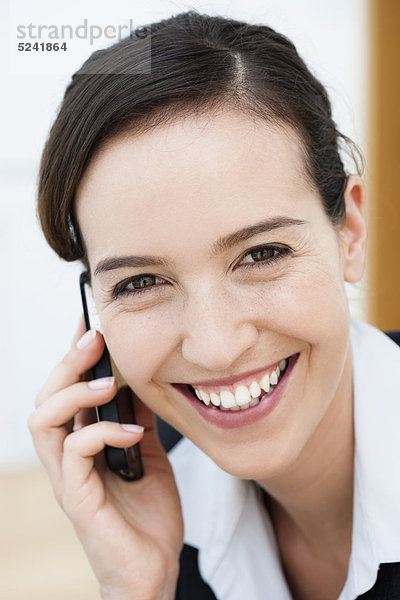 Diessen am Ammersee  Nahaufnahme einer jungen Geschäftsfrau am Handy  lächelnd  Porträt