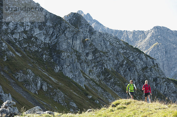 Österreich  Kleinwalsertal  Mann und Frau wandern auf dem Bergweg
