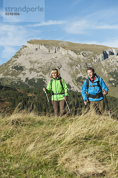 Österreich  Kleinwalsertal  Mann und Frau wandern auf dem Bergweg  lächelnd
