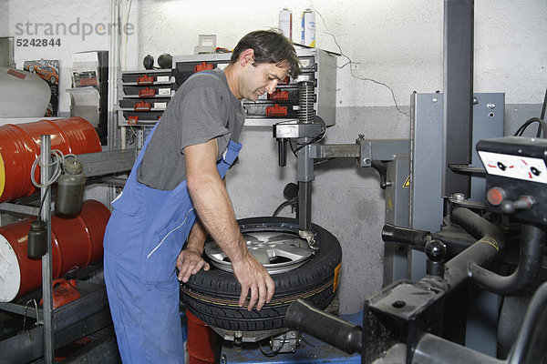 Deutschland  Ebenhausen  Mechatroniker für Reifen in der Autowerkstatt