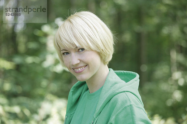 Nahaufnahme einer jungen Frau im Wald  Portrait  Lächeln