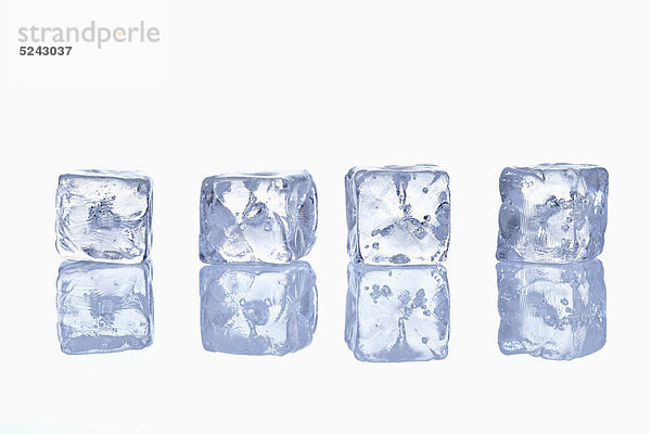 Vier Eiswürfel in Reihe mit Spiegelung auf Glas