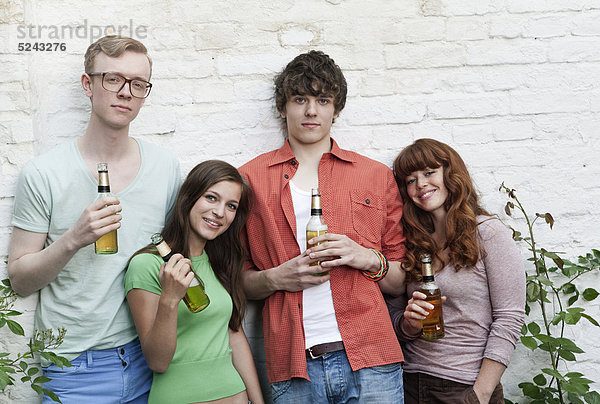 Junge Männer und Frauen mit Bierflaschen  lächelnd  Portrait