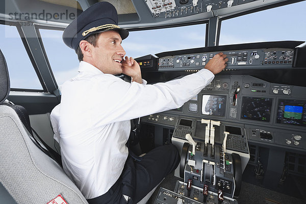 Deutschland  Bayern  München  Pilot mit Handy und Pilotflugzeug aus dem Flugzeug-Cockpit