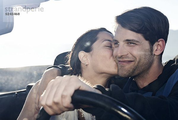 Spanien  Mallorca  Junge Frau küsst Mann im Cabriolet  Nahaufnahme