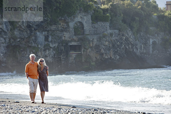 Seniorenpaar geht am Strand spazieren  Italien  Sori