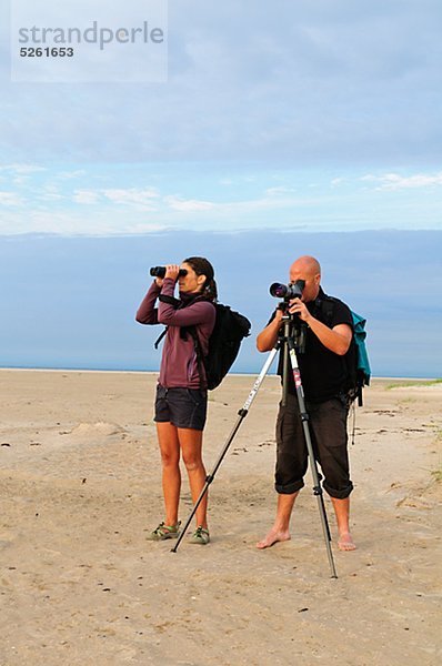 Zwei Leute zu beobachten Vögel am Strand