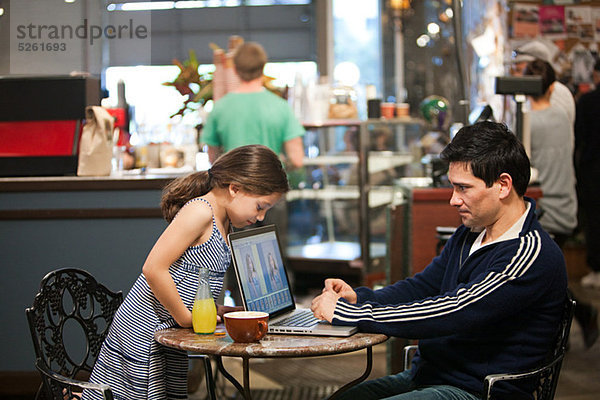 Vater und Tochter mit Laptop im Café