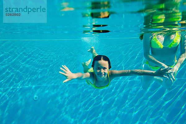 Frau mit Mädchen im Schwimmbad  Unterwasseransicht