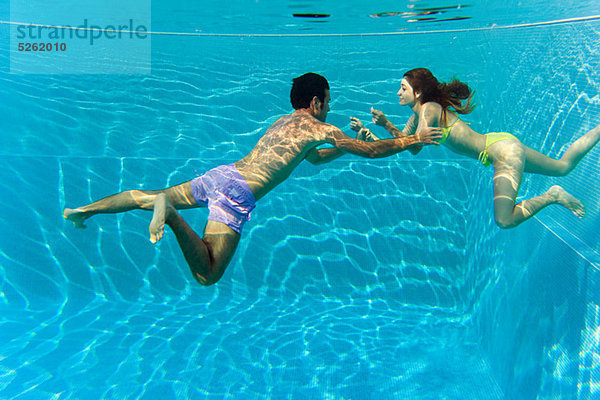 Junges Paar schwimmt im Schwimmbad  Unterwasserblick