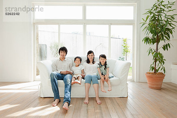 Familie mit zwei Kindern auf Sofa  Portrait