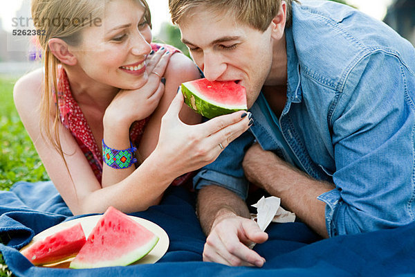 Junge Frau füttert Mann Wassermelone