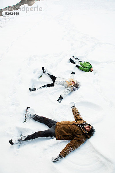 Familie macht Schnee-Engel