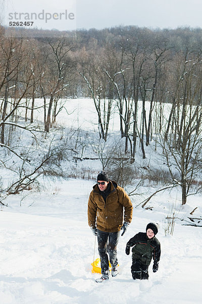 Vater und Sohn  Schlitteln auf Schnee