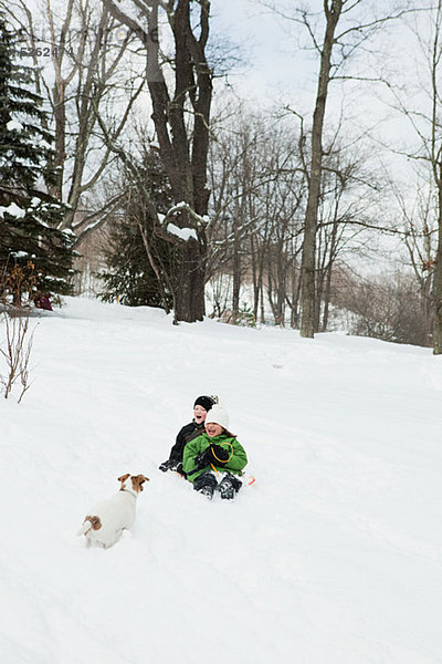 Zwei Kinder Schlitten im Schnee