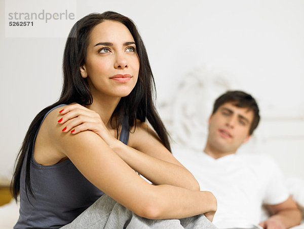 Junges Paar auf dem Bett sitzend  Schwerpunkt im Vordergrund