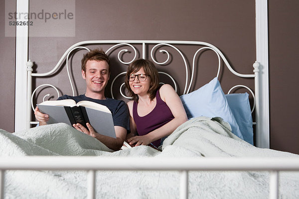 Young couple lesen im Bett