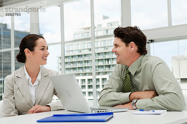 Geschäftsmann und Geschäftsfrau treffen sich im Büro mit Laptop
