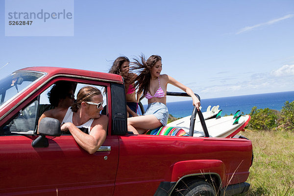 Vier junge Freunde aus Straßenfahrzeug auf Urlaub fahren