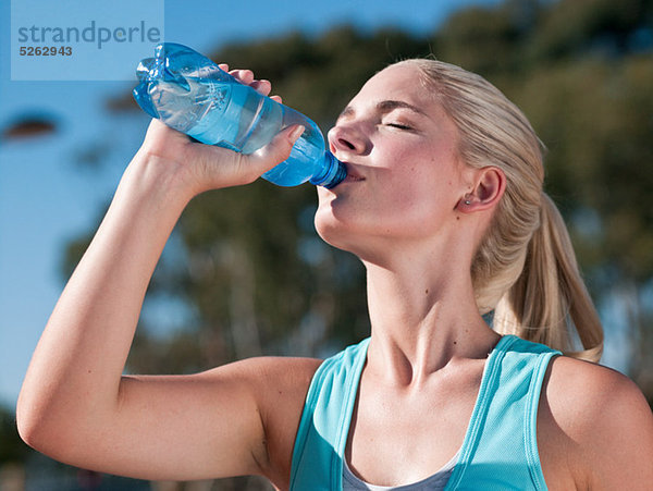 Junge Frau trinkt Mineralwasser