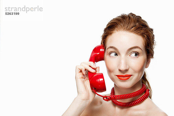 Frau mit roter Telefonschnur um den Hals gewickelt