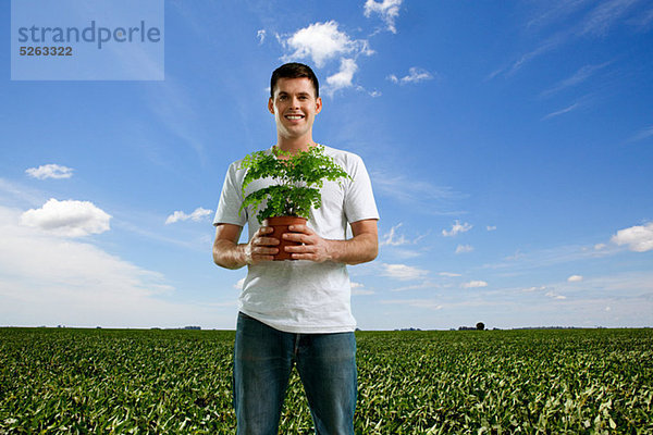 Man holding Plant im Feld