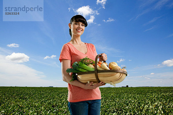 Frau im Feld Holding Basket einheimische Gemüse