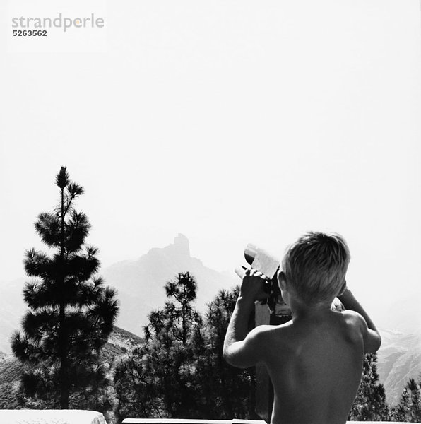 Boy looking at Landschaft durch Teleskop