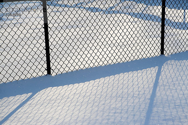 Drahtgitterzaun im Schnee  abstrakt