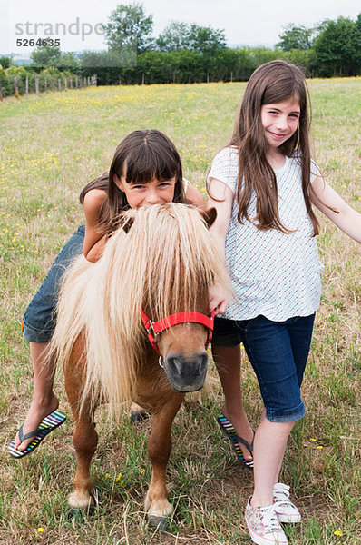 Mädchen mit Pony im Feld