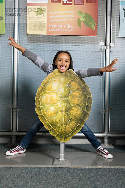 Mädchen steht hinter Kemps Ridley Meeresschildkrötenpanzer