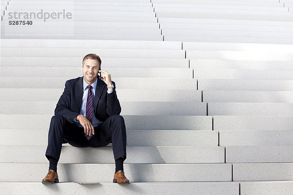 Telefonierender Geschäftsmann auf einer Treppe