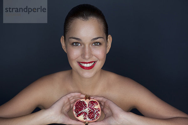 Frau mit halbiertem Granatapfel