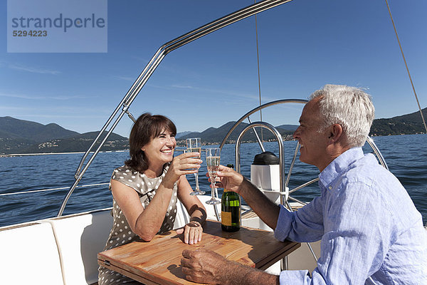 Älteres Paar mit Champagner auf dem Boot