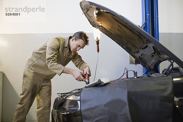 Mechanikerarbeiten am Automotor in der Garage