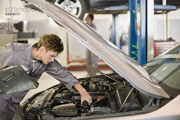 Mechanikerarbeiten am Automotor in der Garage