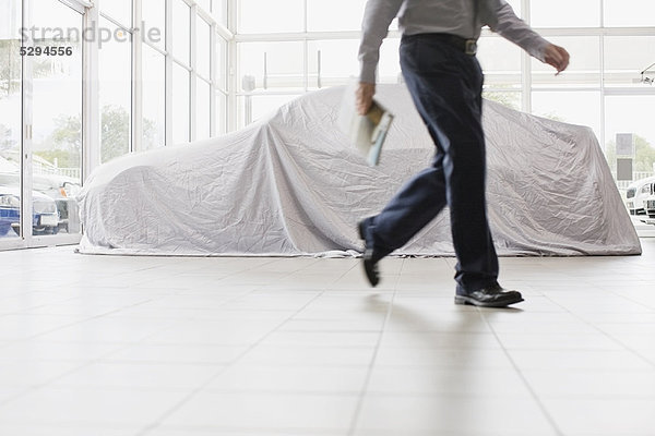 Autoverkäufer zu Fuß im Showroom