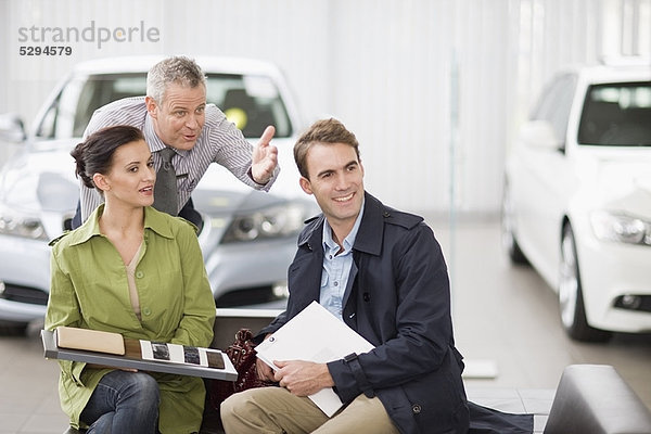 Autoverkäufer im Gespräch mit einem Paar