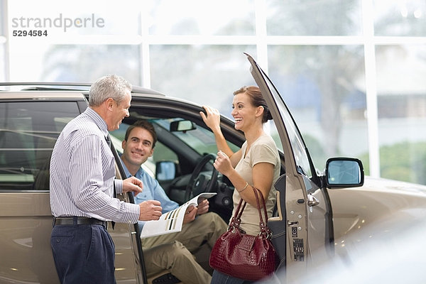 Verkäufer zeigt Auto im Showroom