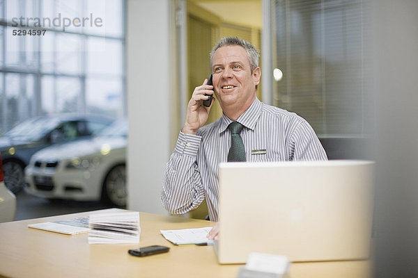 Autoverkäufer am Telefon im Showroom