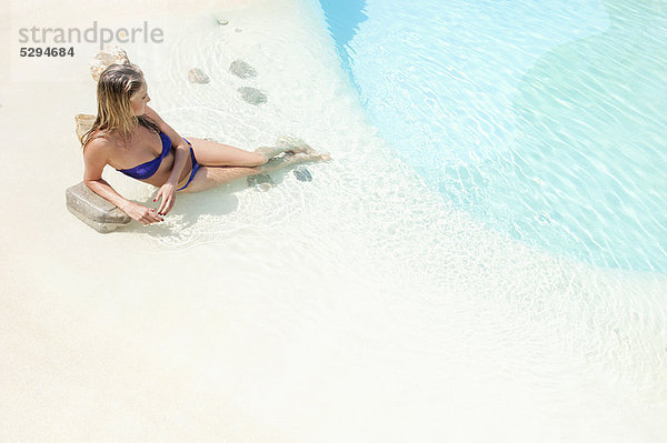 Frau entspannt sich am Schwimmbad