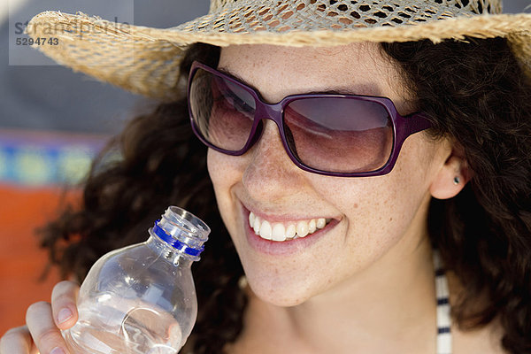 Lächelnde Frau trinkt Wasser