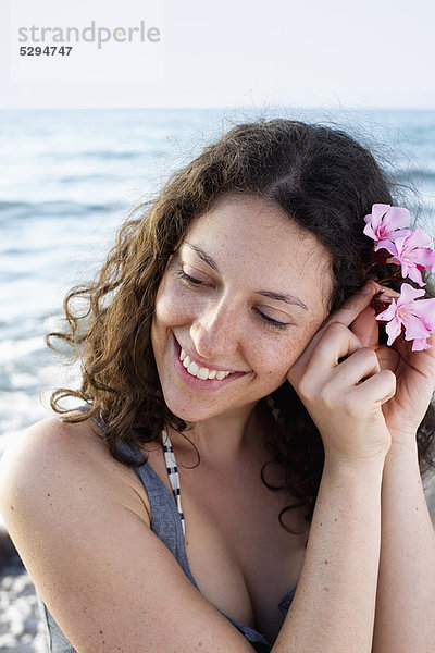 Lächelnde Frau mit Blume im Haar