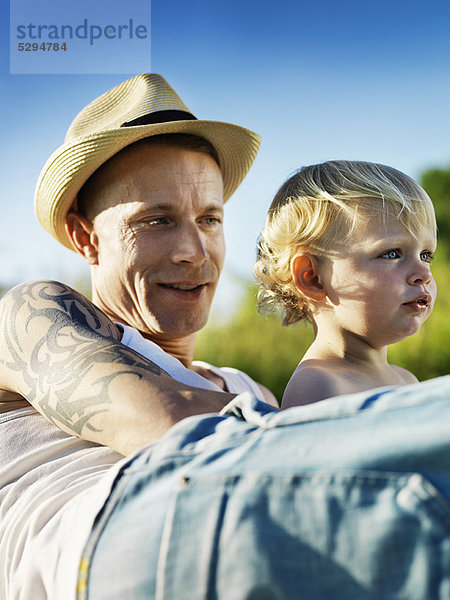 Vater sitzend mit Kind im Freien