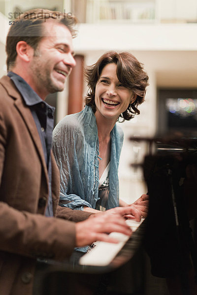 Paare  die zu Hause zusammen Klavier spielen