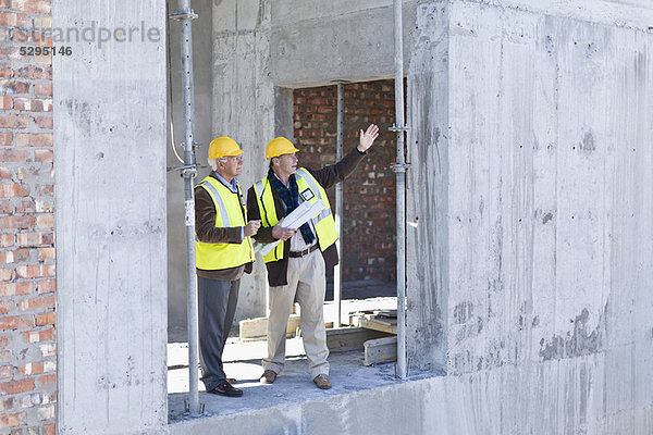 Geschäftsmann und Arbeiter im Gespräch vor Ort