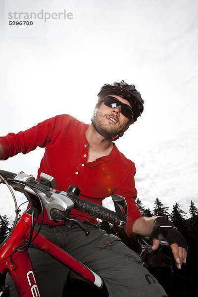 Mann in rotem Shirt auf einem Mountainbike